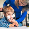 Mother helping child blow their nose