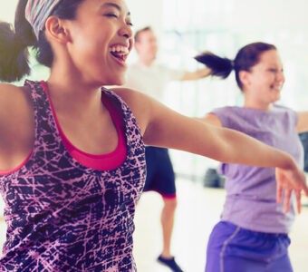 Group of people smiling while exercising in a workout studio