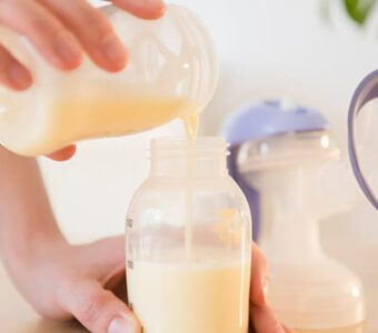 Person pouring breast milk into bottle