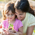 Mother and daughter holding a small plant in a pot