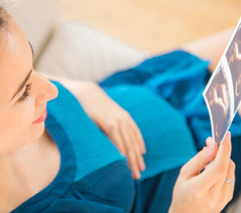 Pregnant person holding an ultrasound