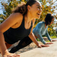 people doing wall push ups outside smiling