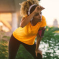 Person wiping forehead while resting during a sunny run outside