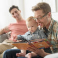 Parents reading a book to a baby