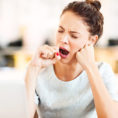 Person yawning at their desk during work