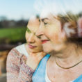 Adult child hugging and showing support for older parent