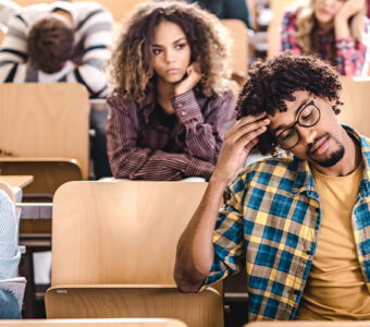 Group of young adults looking stressed in classroom