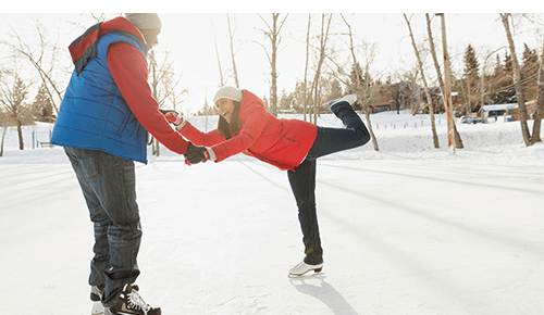 Couple Ice Skating on frozen pond in Winter