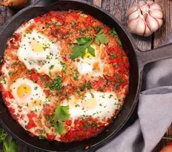 Cast iron pan filled with shakshuka and eggs