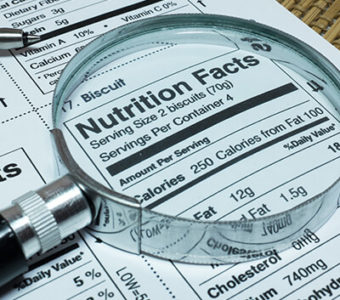 Closeup of nutrition label on food packaging using magnifying glass