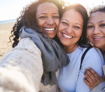 Three generations of women smiling outside