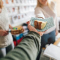 Closeup of person being handed a slice of cake in an office setting