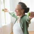 Smiling woman working out with dumbbells