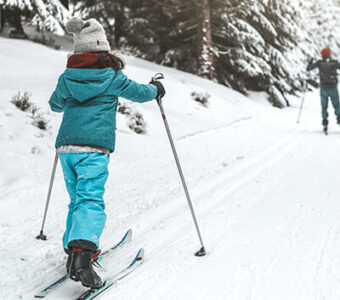 Family cross country skiing in snowy forest