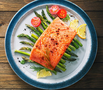 Plate with cooked salmon sitting on top of asparagus