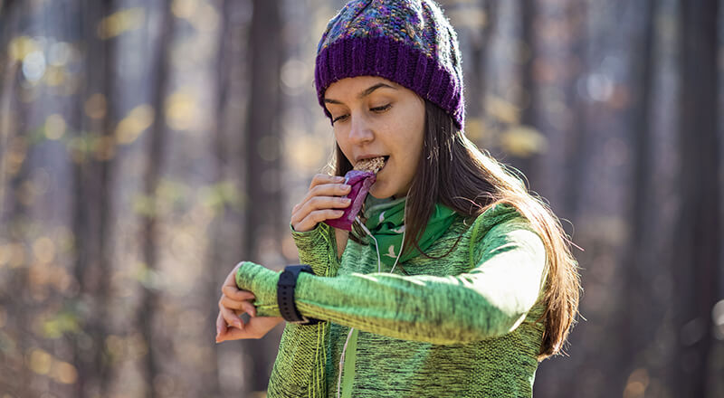 Person eating a healthy snack while checking their watch