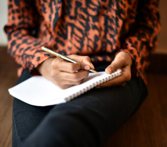 Person writing on Notepad