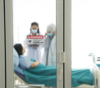 Patient in hospital bed talking with doctors