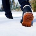 Closeup of someone walking in the snow wearing winter boots