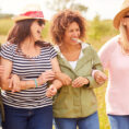 Four middle-aged people smiling while walking outside