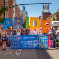 OhioHealth associates at Columbus Pride Parade holding up a rainbow 