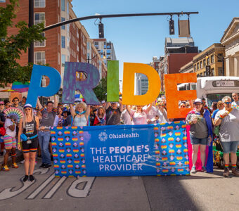 OhioHealth associates at Columbus Pride Parade holding up a rainbow 