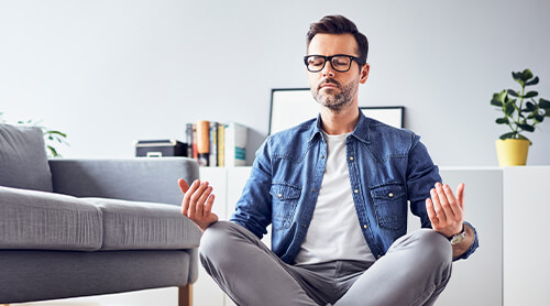 Person meditating with eyes closed and legs crossed