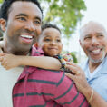 Man with son on his back next to his older father