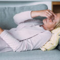 Person laying on a couch experiencing stroke like symptoms