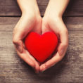 Closeup of hands holding a red heart