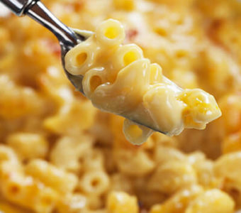 Fork with macaroni and cheese from bowl