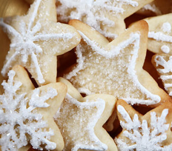 Closeup of sugar cookies in snowflake shapes with white frosting