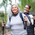 Couple walking on a trail outdoors using walking poles