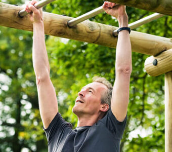 Man exercising on bars in outdoor workout area