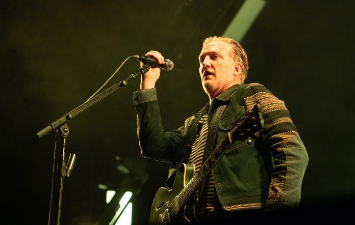 Josh Homme performing live on stage with Queens Of The Stone Age