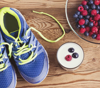 Athletic shoes sitting on ground next to healthy foods