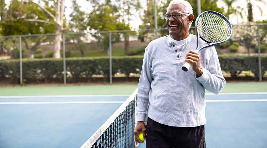 Person playing tennis on a court outside