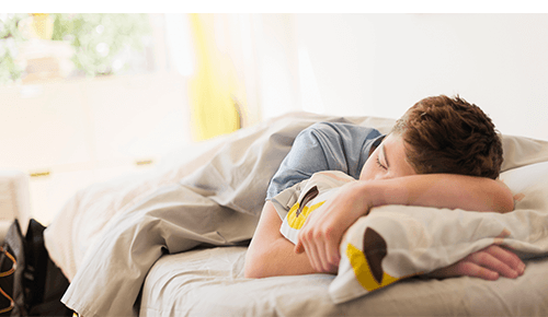 Teenager asleep in bed