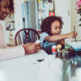 Parent and child doing crafts and painting at table