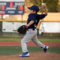 Child throwing a baseball from the pitcher's mound on a baseball field