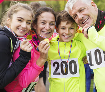 Family holding up medals after running a race