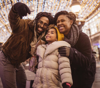 Family taking picture in front of holiday light display