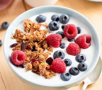 Bowl of yogurt with granola and berries on top