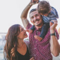 Family with child walking on a beach near a body of water