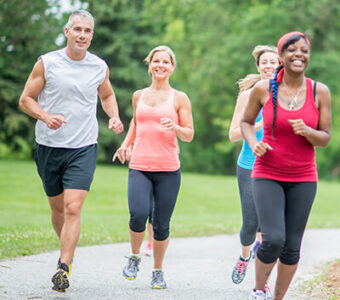 Group of adults running outside on a path