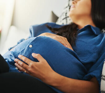 Pregnant woman asleep with hands on stomach