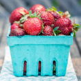 Small blue container of strawberries