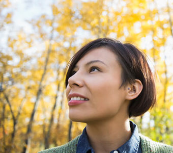 Woman standing outside looking off into distance