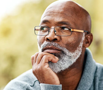 Man sitting outside looking thoughtfully in the distance